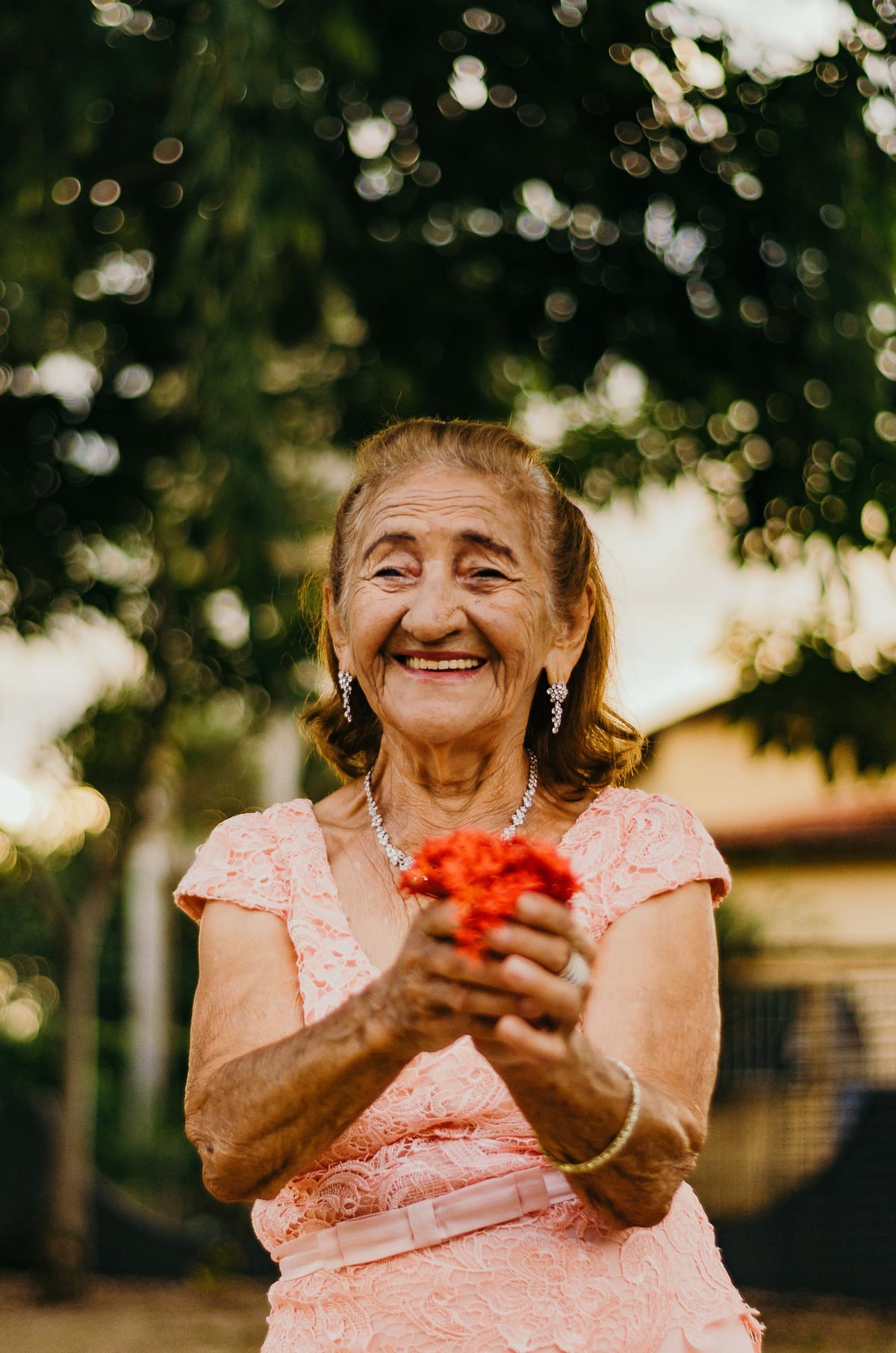 Senhora sorridente ao ar livre, segurando flores